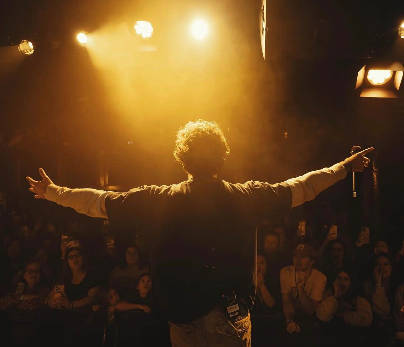 Mark on stage, arms wide open